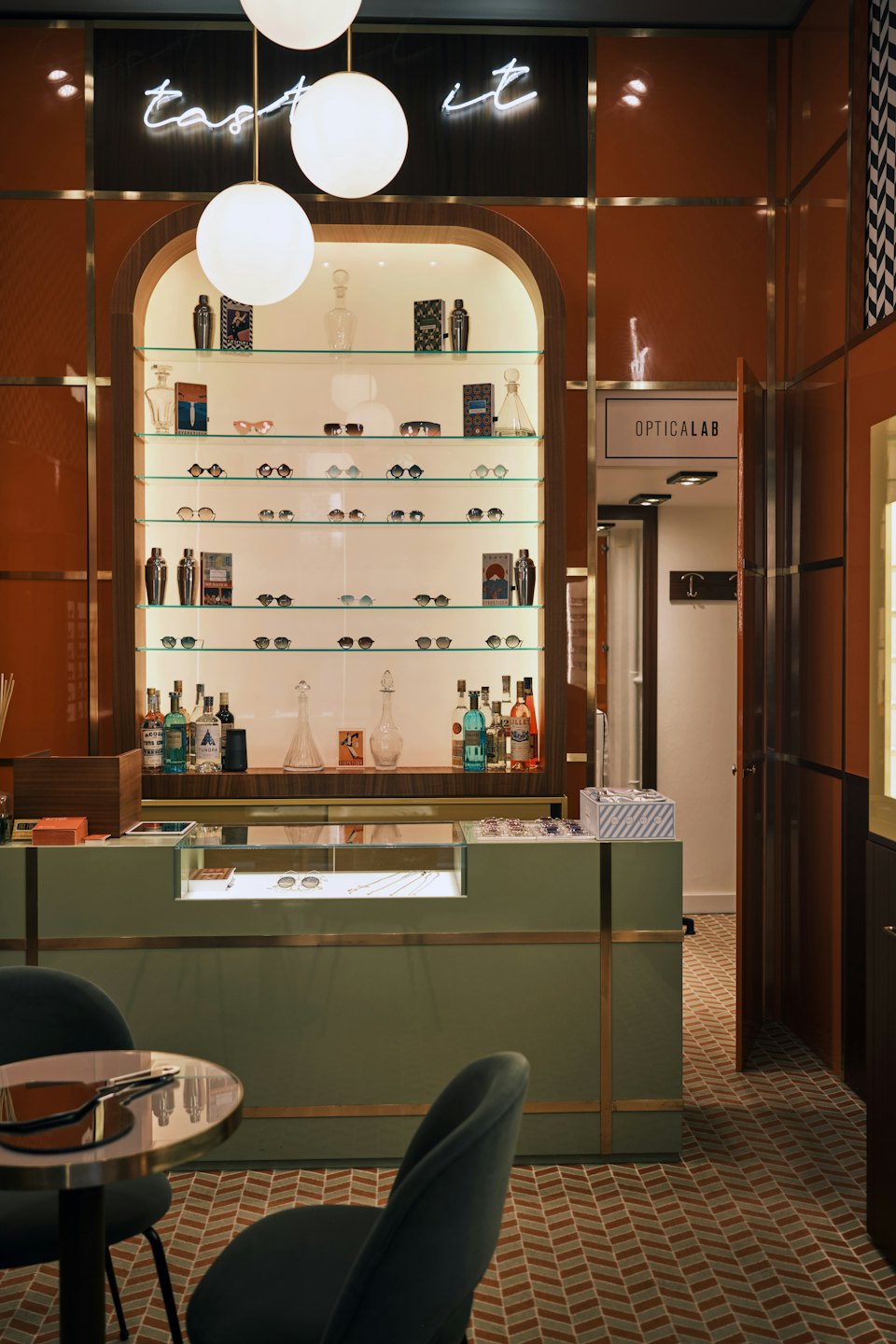 Optical boutique interior with shelves of glasses and pendant lights.